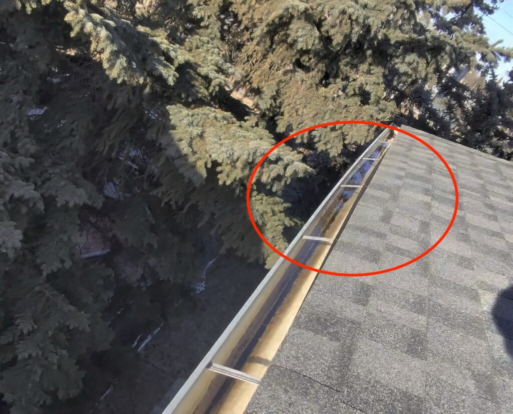 Gutter hanging due to water overflow, illustrating the importance of regular maintenance – How often should gutters be cleaned?